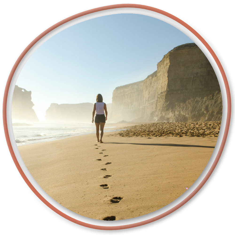 Woman walking alone on a beach, symbolizing inner growth and self-discovery.