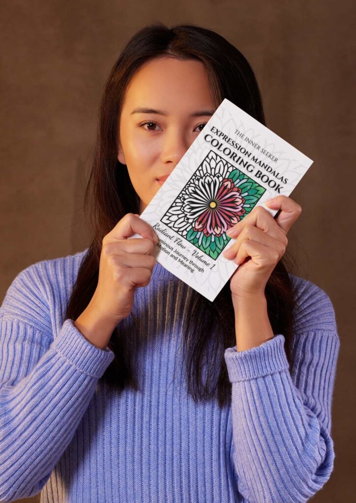 Woman holding the Expression Mandalas Coloring Book with mandala flower design on the cover