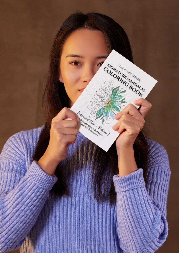 Woman holding Signature Mandalas Coloring Book – Botanical Flow by The Inner Seeker
