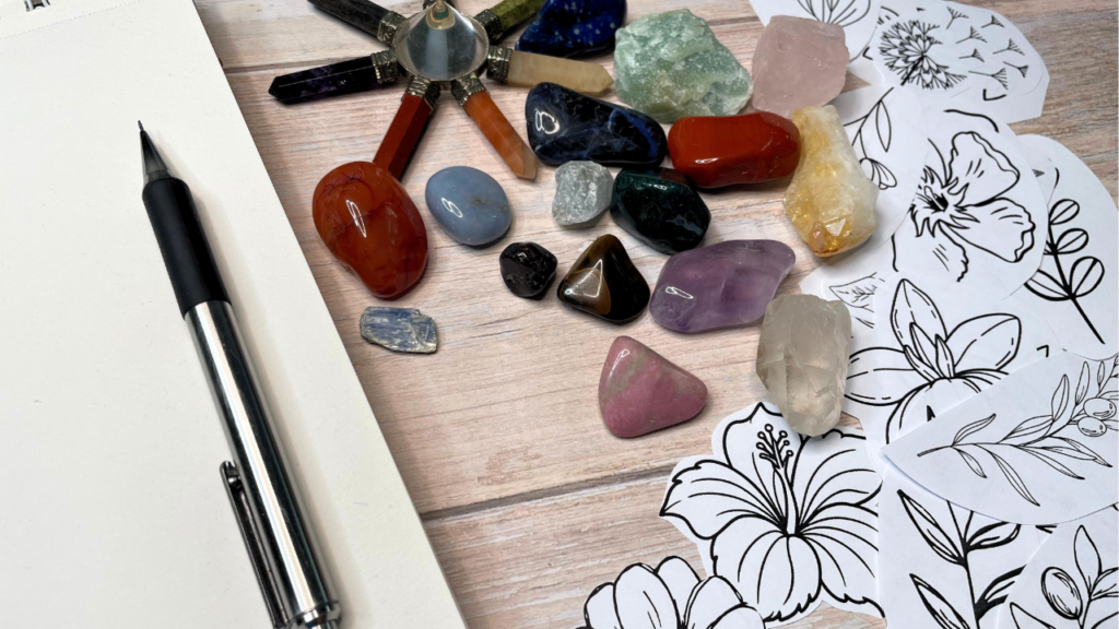 Collection of archetype stones and crystals with botanical cutouts and art journal
