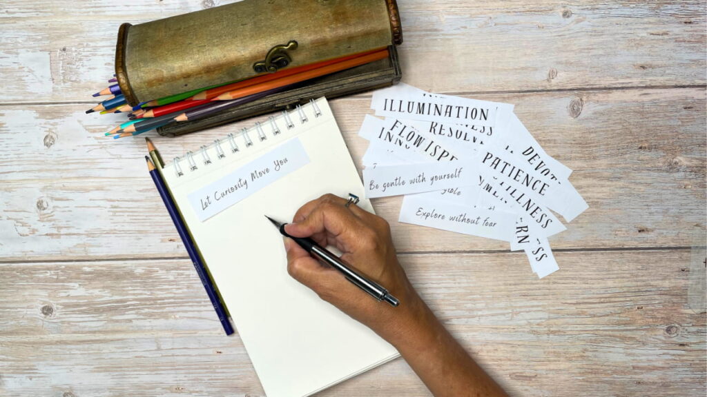 Art journal prompts for self-discovery laid out with phrase cards and colored pencils