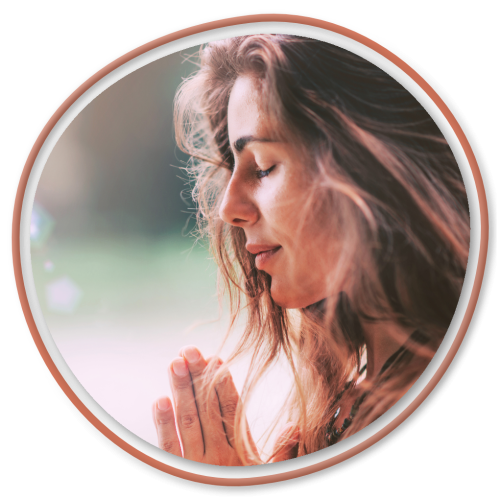 Woman meditating with hands in prayer pose and eyes closed